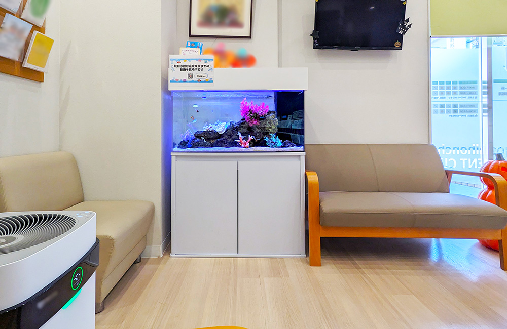 待合室のソファの間に設置された海水魚水槽の全景