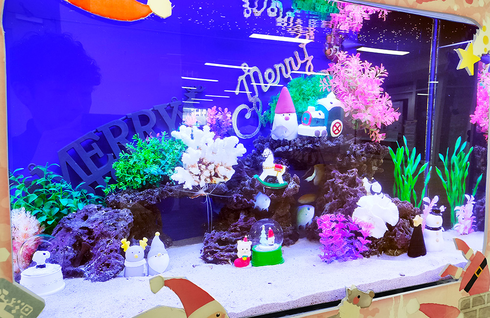 クリスマス装飾とサンタの置物がある青い照明の水槽